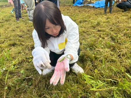 昆虫を手に見つめる女性