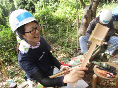笑顔で竹細工を作る女性