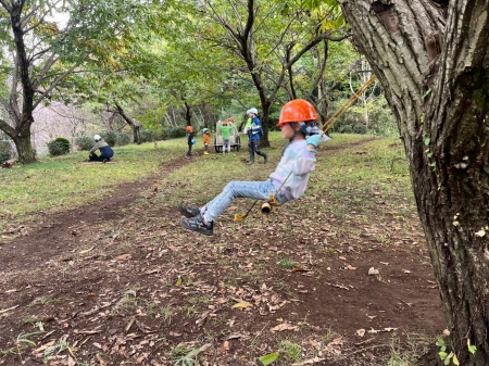 すっきりした広場のブランコをこぐ子ども